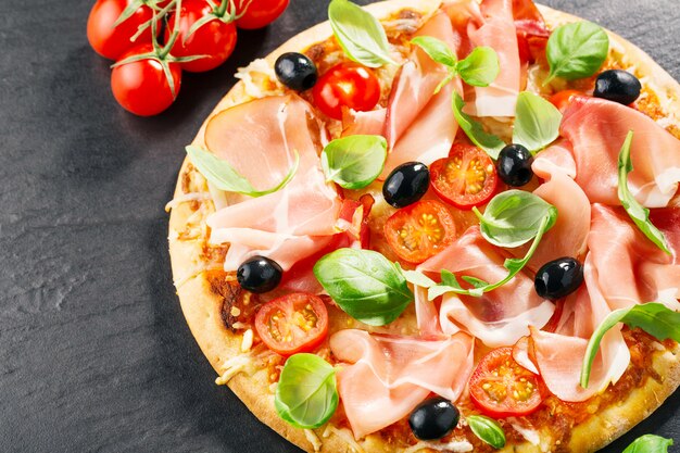 Draufsicht der frischen appetitanregenden Pizza auf Dunkelheit