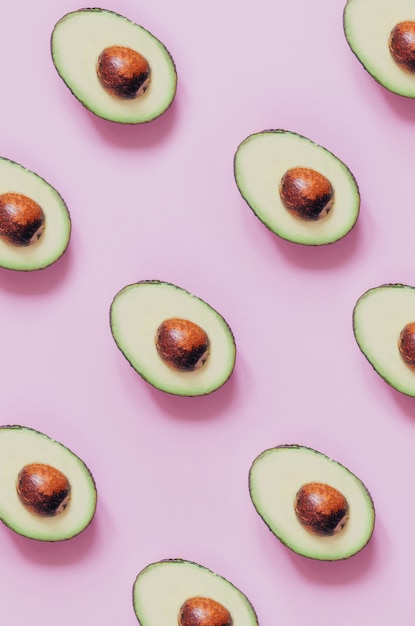 Draufsicht der geschnittenen Avocado auf rosa Hintergrund