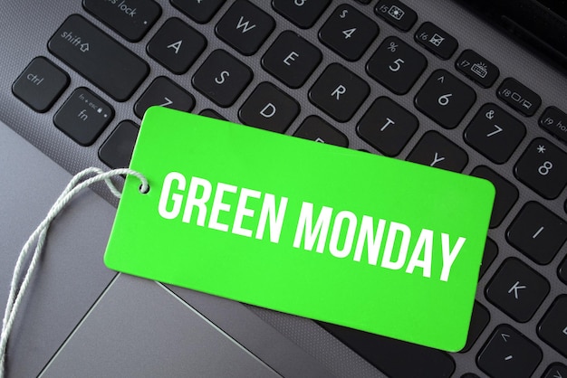 Draufsicht der grünen Papierkarte und des Textes grüner Montag auf einem Laptophintergrund