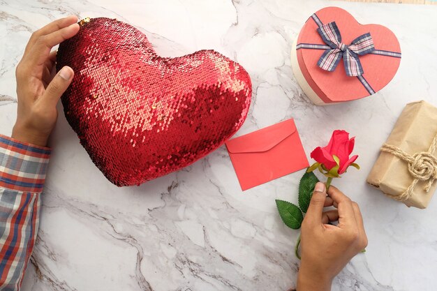 Draufsicht der Hand des Mannes, die eine Geschenkbox auf Tisch hält