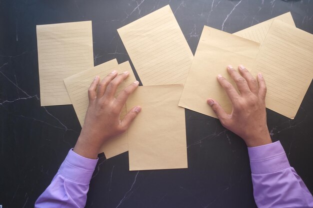 Draufsicht der jungen msn-hand auf leerem papier auf dem tisch