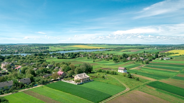 Draufsicht der ländlichen Landschaft am sonnigen Frühlingstag. Haus und grünes Feld. Drohnenfotografie