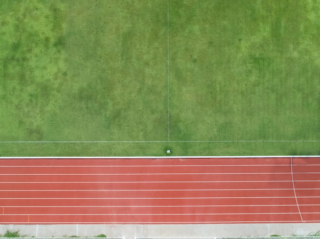 Draufsicht der Luft über Hälfte des Fußballplatzes, Fußballplatz mit roter Laufbahn.