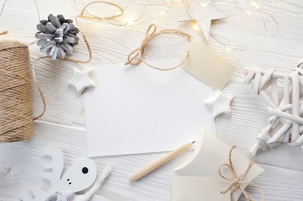 Draufsicht der Modell-Weihnachtsgrußkarte, Flatlay auf einem weißen hölzernen Hintergrund