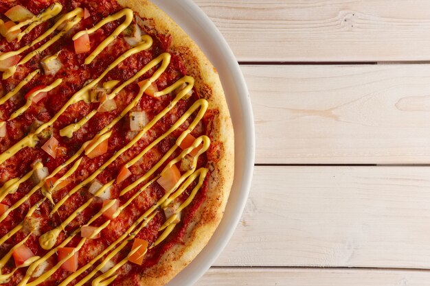 Draufsicht der Pizza mit sonnengetrockneten Tomaten und Senfsoße