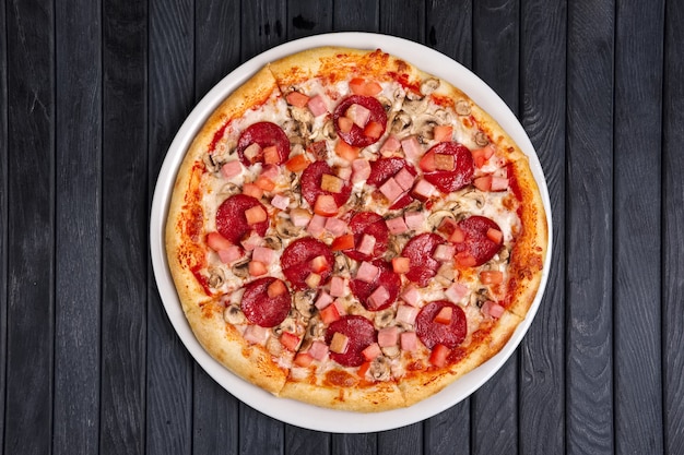 Draufsicht der Pizza mit Wurst, Schinken und Tomate