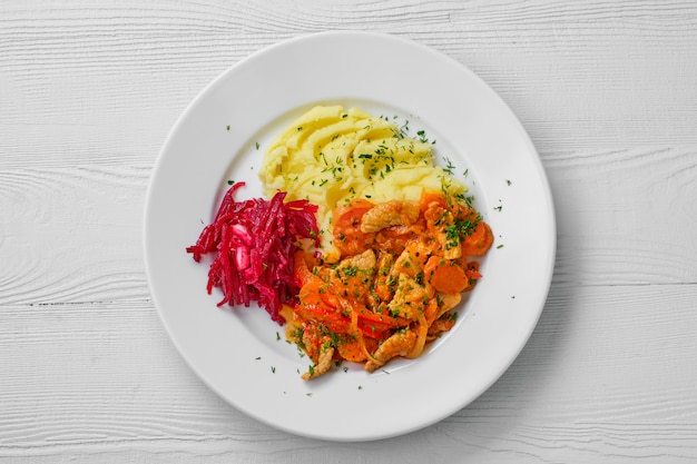 Draufsicht der Platte mit Rindergulasch, Kartoffelpüree und Rote-Bete-Salat