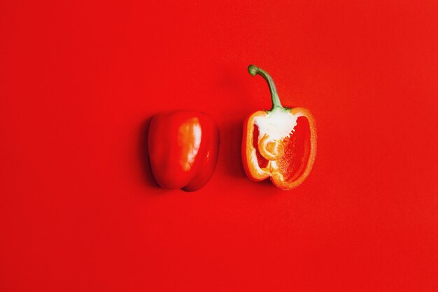 Draufsicht der roten Paprika halbiert auf rotem Hintergrund