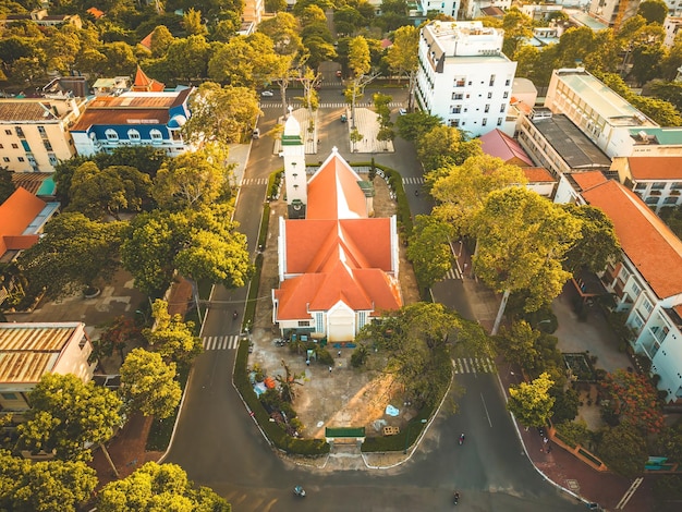 Draufsicht der schönen alten Kirche der Stadt Vung Tau mit grünem Baum Katholisches Tempeldorf Vung Tau Vietnam Foto der Frühlingslandschaft mit Sonnenuntergang