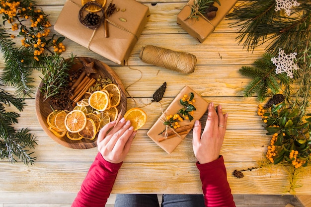 Draufsicht der weiblichen Hände am Tisch Prozess des Verpackens von Weihnachtsgeschenken