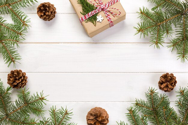 Draufsicht der Weihnachtsdekoration mit Tannenbaum und Geschenkbox auf Holztisch