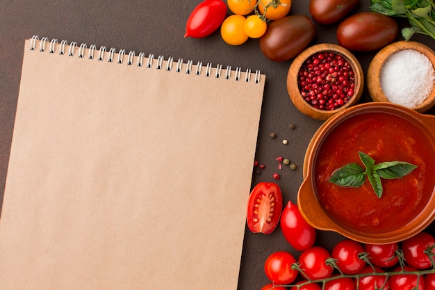 Foto draufsicht der wintertomatensuppe in der schüssel mit notizbuch