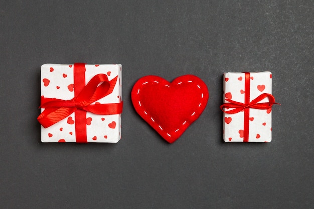 Draufsicht des bunten Valentinsgrußhintergrundes gemacht von den Geschenkboxen und von den roten Textilherzen.