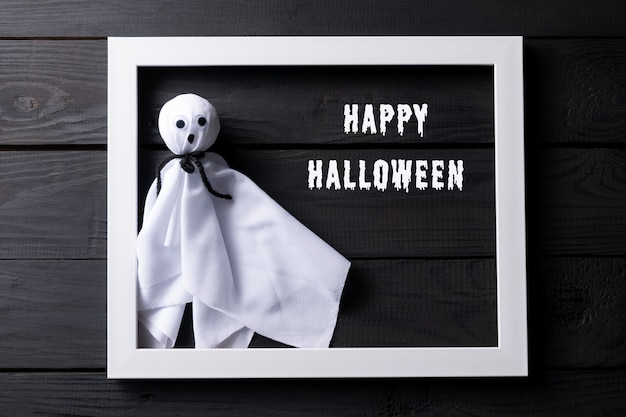 Foto draufsicht des halloween-handwerks, stoffgeist auf schwarzem holz mit text.