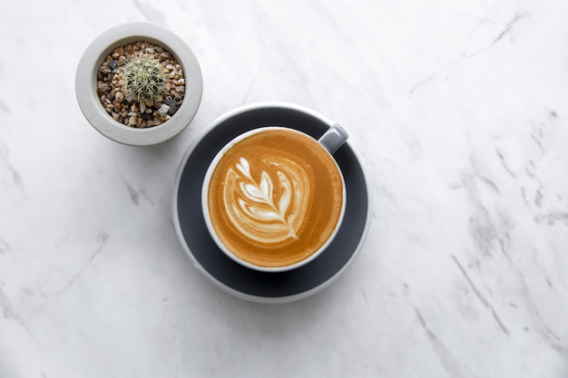 Draufsicht des heißen Cappuccinos in der Kaffeetasse auf Marmortabelle