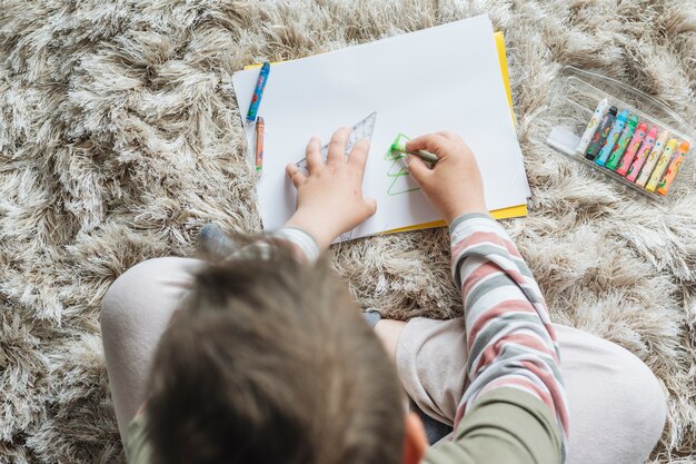 Draufsicht des Jungen zu Hause malend