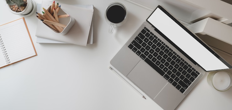 Foto draufsicht des modernen büroraumes mit laptop-computer und büroartikeln des offenen leeren bildschirms