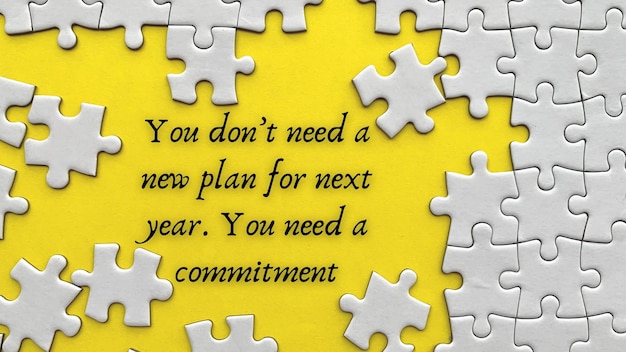 Draufsicht des Textes auf gelbem Einband Sie brauchen keinen neuen Plan für das nächste Jahr Sie brauchen eine Zusage mit Puzzleteil-Hintergrund
