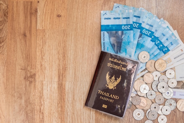 Draufsicht des thailändischen Passes mit Währungsmünzen mit Bargeld von nok