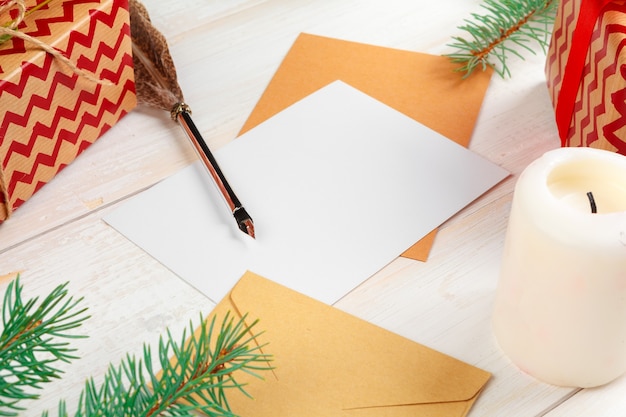 Draufsicht des Weihnachtsbriefschreibens auf gelbem Papier auf hölzernem Hintergrund mit Dekorationen
