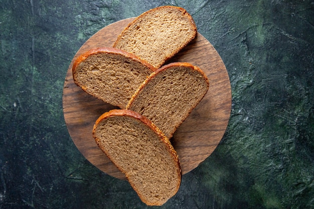 Draufsicht dunkle Brotlaibe auf dunklem Schreibtisch