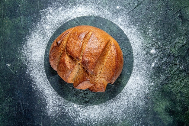 Draufsicht dunkles Brot mit Mehl auf dunklem Schreibtisch