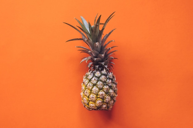 Draufsicht einer Ananas auf einem orange Hintergrund