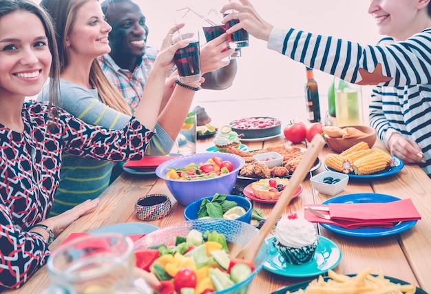 Foto draufsicht einer gruppe von menschen, die zusammen zu abend essen, während sie am holztisch sitzen essen auf dem tisch die leute essen fast food