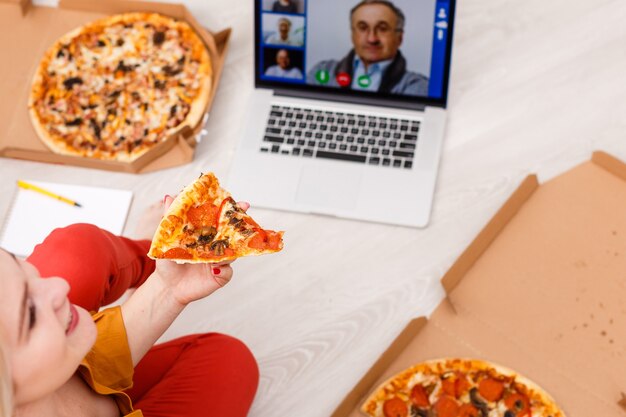 Draufsicht einer jungen Frau, die mit Laptop auf dem Boden sitzt