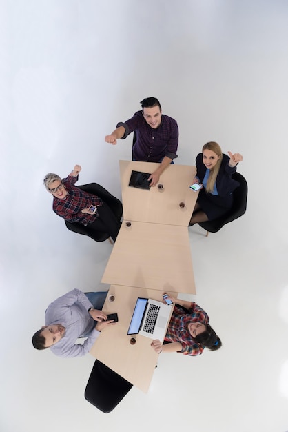 Draufsicht einer multiethnischen Gruppe von Startup-Geschäftsleuten beim Brainstorming-Treffen in einem modernen, hellen Bürointerieur