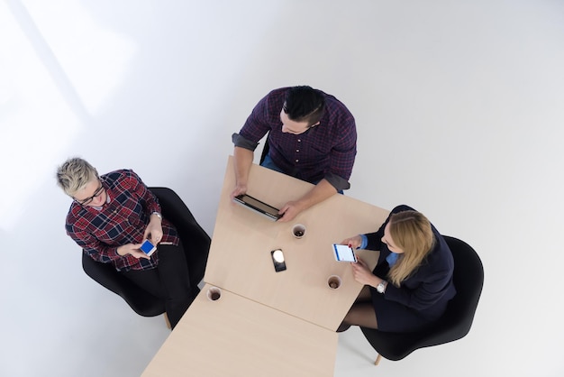 Draufsicht einer multiethnischen Gruppe von Startup-Geschäftsleuten beim Brainstorming-Treffen in einem modernen, hellen Bürointerieur