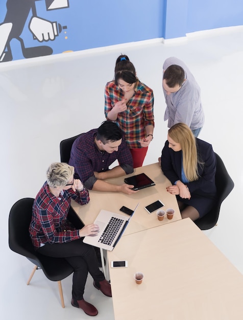 Draufsicht einer multiethnischen Gruppe von Startup-Geschäftsleuten beim Brainstorming-Treffen in einem modernen, hellen Bürointerieur