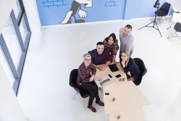 Draufsicht einer multiethnischen Gruppe von Startup-Geschäftsleuten beim Brainstorming-Treffen in einem modernen, hellen Bürointerieur