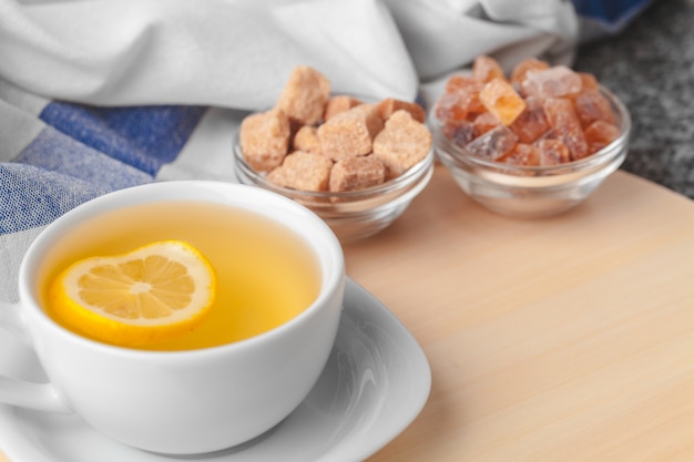 Draufsicht einer Tasse Tee mit Zitronenstück auf Holztisch