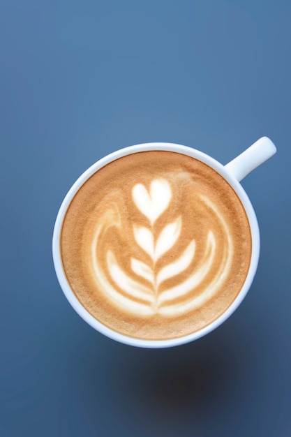 Draufsicht eines Bechers Latte Art auf dunklem Hintergrund