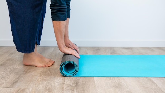 Draufsicht eines kaukasischen Mannes mit Trainingsmatte, der sich auf das Yoga-Sporttraining im Haus vorbereitet Meditieren und Fitness-Workout-Übungen zu Hause