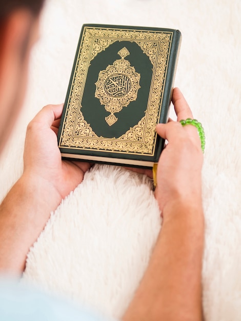 Draufsicht eines Mannes, der Quran hält