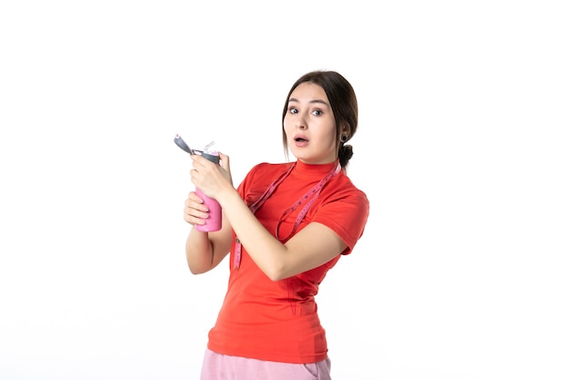 Draufsicht eines schockierten jungen Mädchens in roter Bluse mit Messgerät und Thermoskanne auf weißem Hintergrund