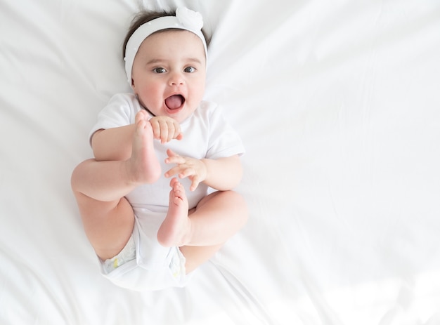 Draufsicht entzückendes Baby, das im Bett spielt