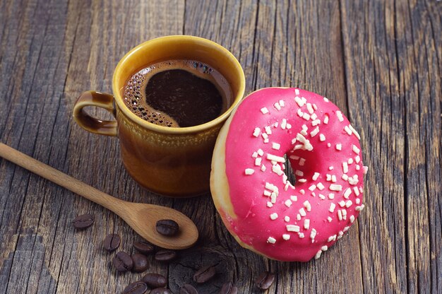 Draufsicht Erdbeerdonut im Teller mit Tasse Kaffee