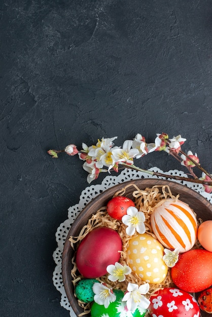Draufsicht farbig gestaltete Eier in brauner Platte dunkler Hintergrund Frühling verzierten horizontalen Urlaub novruz