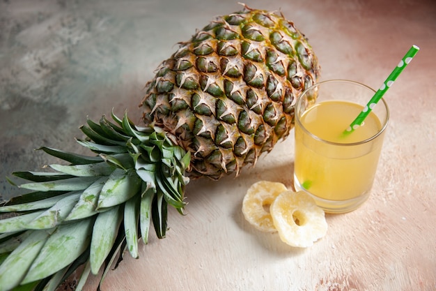 Draufsicht frische Ananas, die Saftglaspipette trockene Ananasringe auf beigem Hintergrund niederlegen