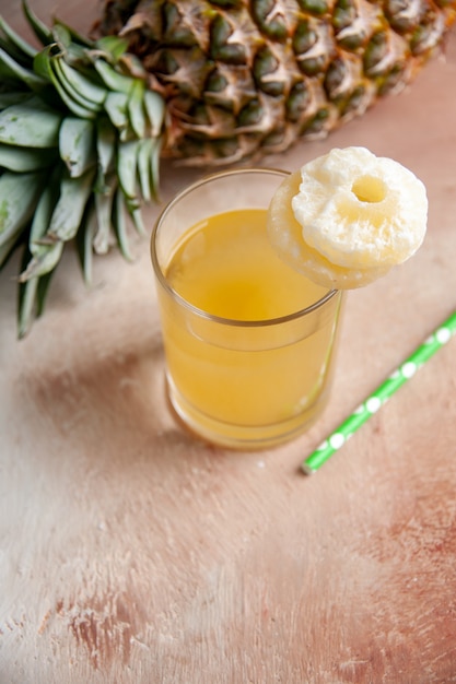 Draufsicht frische Ananas, die Saftpipette auf beigem Hintergrund niederlegt