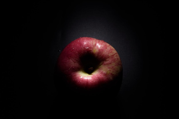 Draufsicht frischer roter Apfel Auf einem schwarzen Hintergrund mit Wassertröpfchen fallen Lichter mit Platz für Text