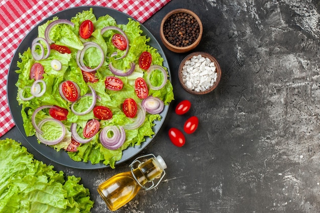 Draufsicht Frischgemüsesalat mit Zwiebeln grüner Salat und Tomaten auf grauem Hintergrund Gesundheitsfoto Farbe reifer Salat Lebensmittel Diät Mahlzeit Freiraum