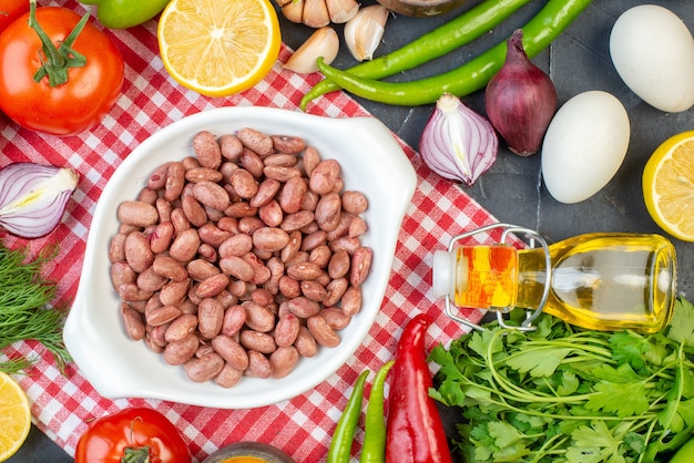 Draufsicht gekochte Bohnen mit Grüns und frischem Gemüse auf der dunklen Hintergrundfarbe Mahlzeit Mittagessen Snack Salat Gesundheit Diät Essen