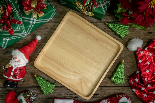 Draufsicht, hölzerne Teller Dekoration mit Geschenkbox und Lichtern am guten Rutsch ins Neue Jahr