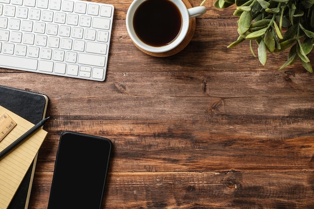 Foto draufsicht holztisch mit notebook und handy mit computer zu hause