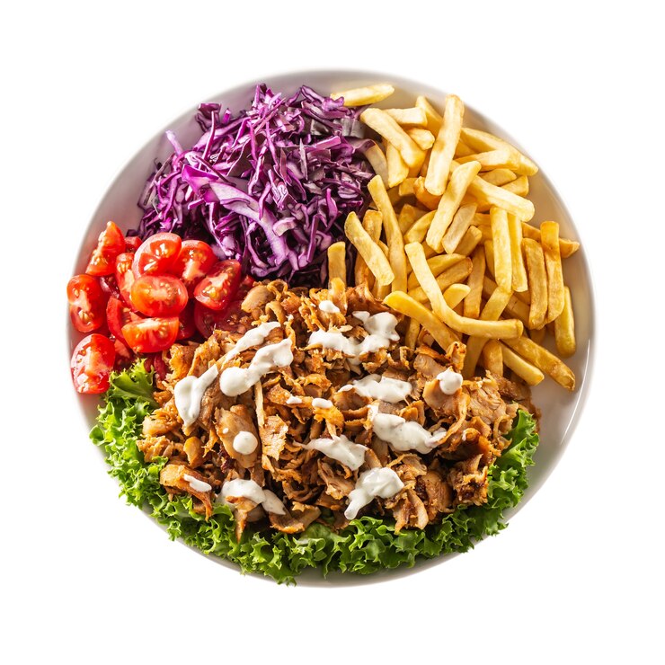 Draufsicht isolierter traditioneller türkischer Hühnerkebab mit schönen Pommes, frischem Gemüse und leckerem Dressing.