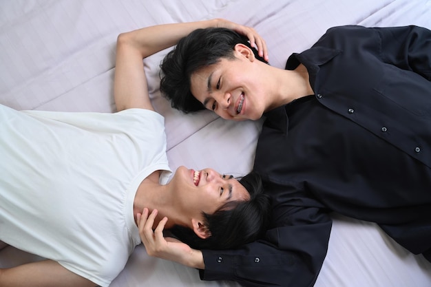 Draufsicht junges schwules Paar, das sich auf dem Bett hinlegt und Zeit miteinander verbringt LGBT-Stolzbeziehungen und Gleichberechtigungskonzept